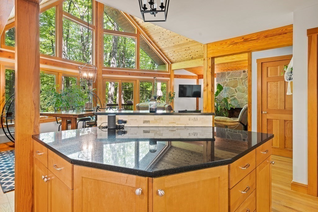 56 Southampton Road Westhampton, MA 01027 - Photo 17 of 42 a dining table with granite countertop a large window and a wooden floor