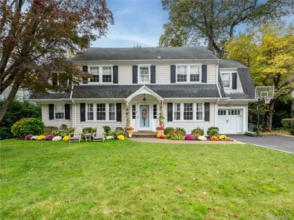 a front view of a house with a big yard and potted plants