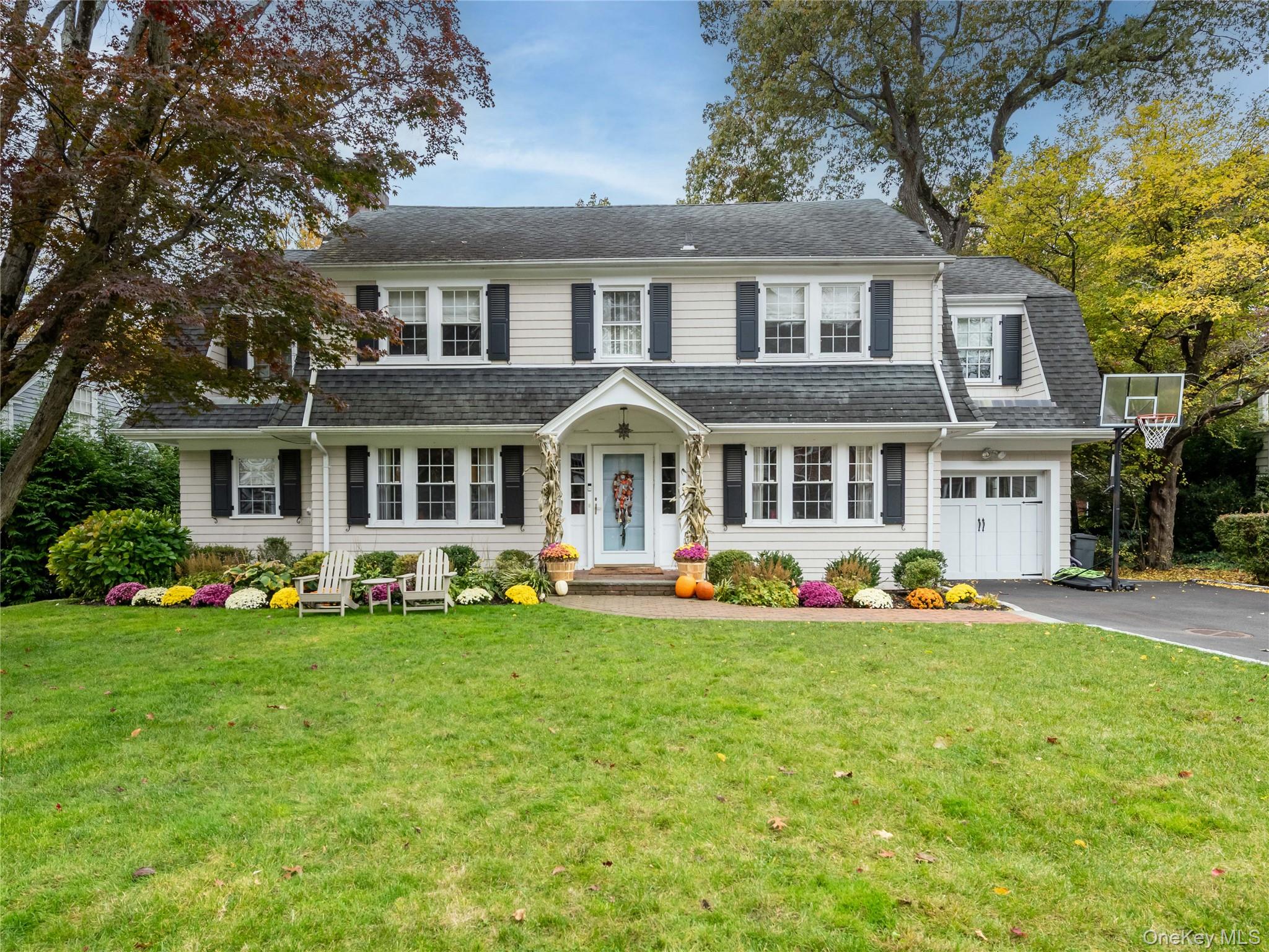 a front view of a house with a big yard and potted plants
