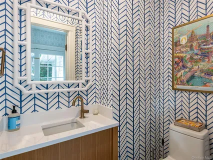 a bathroom with a sink a toilet and a mirror