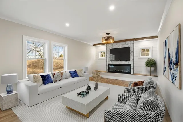 a living room with furniture a flat screen tv and a fireplace