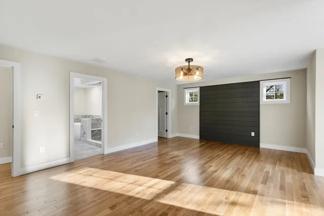 a view of empty room with wooden floor and entryway