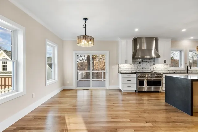a kitchen with stainless steel appliances granite countertop a stove a sink and a wooden floors