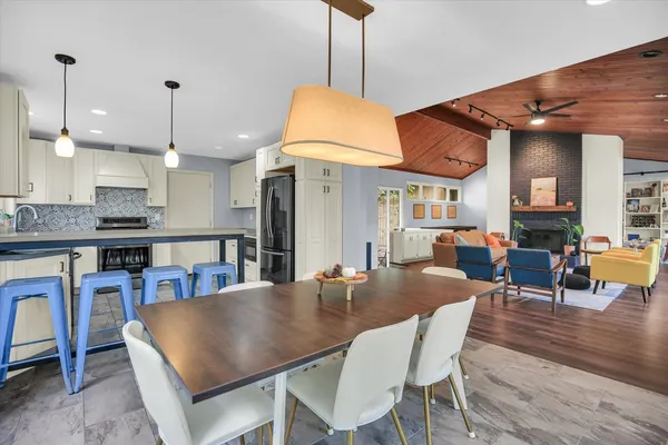 a kitchen with stainless steel appliances granite countertop a refrigerator a stove and a sink with wooden floor