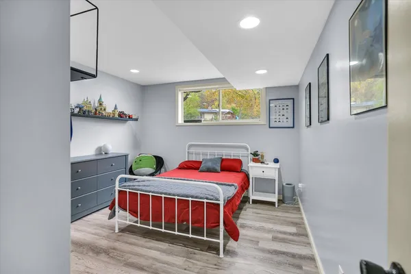 a bedroom with a bed and wooden floor