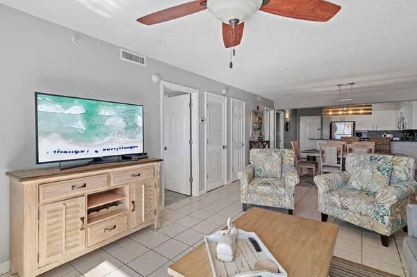 a living room with furniture and a dining table with kitchen view