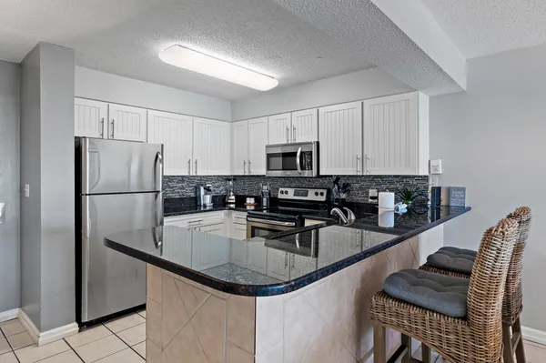a kitchen with stainless steel appliances a sink a stove and cabinets