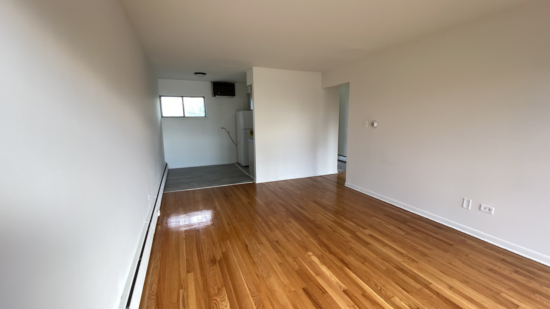 605 North Wolf Road, Unit D11 Hillside, IL 60162 - Photo 7 of 10 an empty room with wooden floor and windows