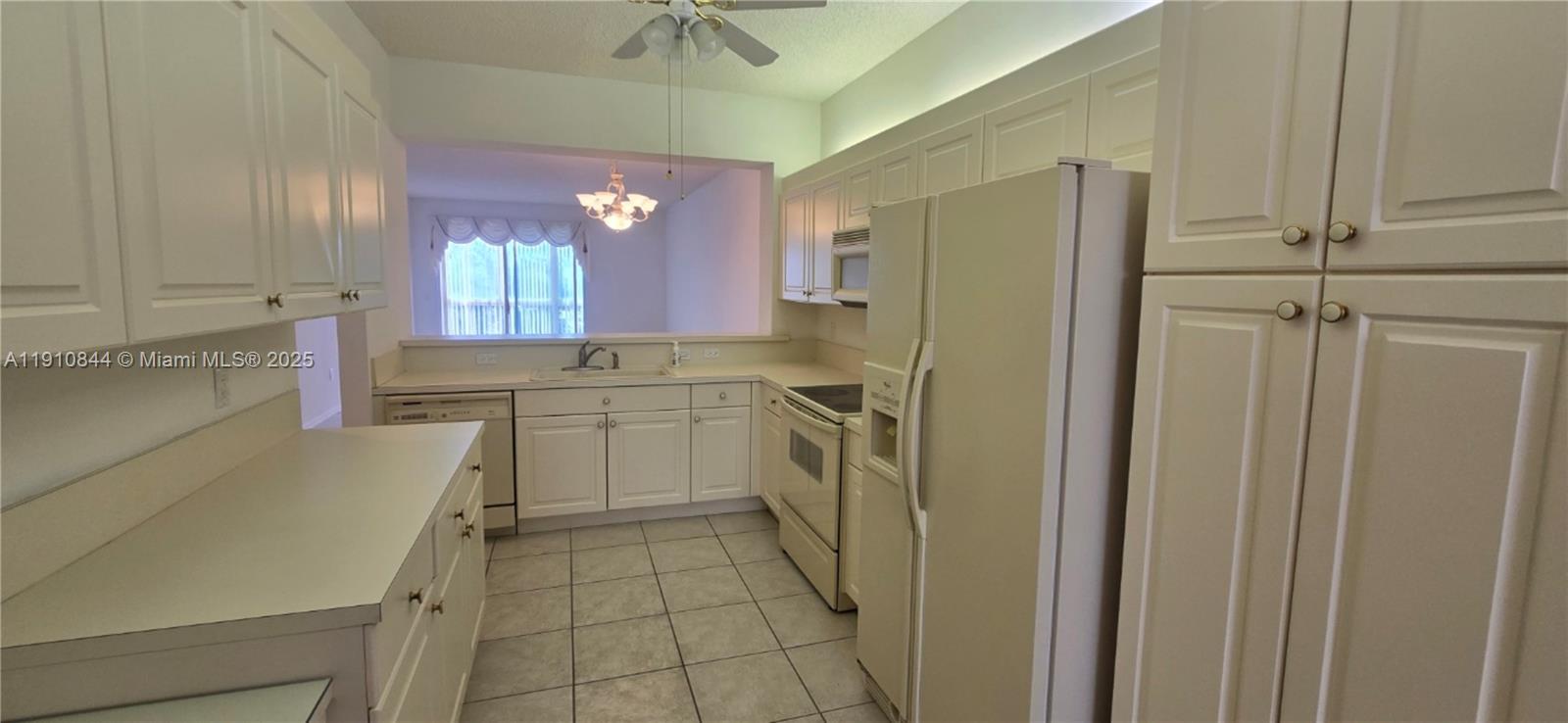 7775 Southampton Terrace, Unit 305 Tamarac, FL 33321 - Photo 6 of 39 a kitchen with a sink cabinets and window