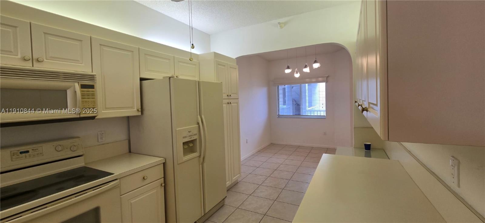 7775 Southampton Terrace, Unit 305 Tamarac, FL 33321 - Photo 8 of 39 a kitchen with a refrigerator and cabinets