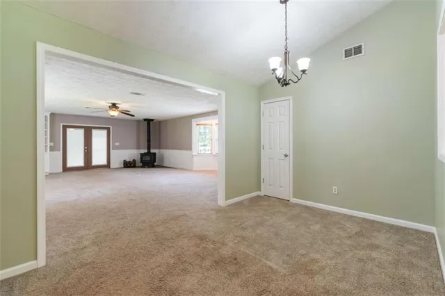 an empty room with windows and a ceiling fan