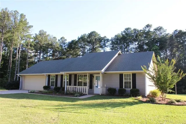 a view of a house with backyard and trees