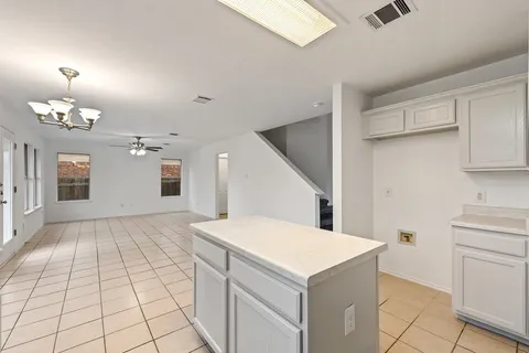 a kitchen with a cabinets and chandelier
