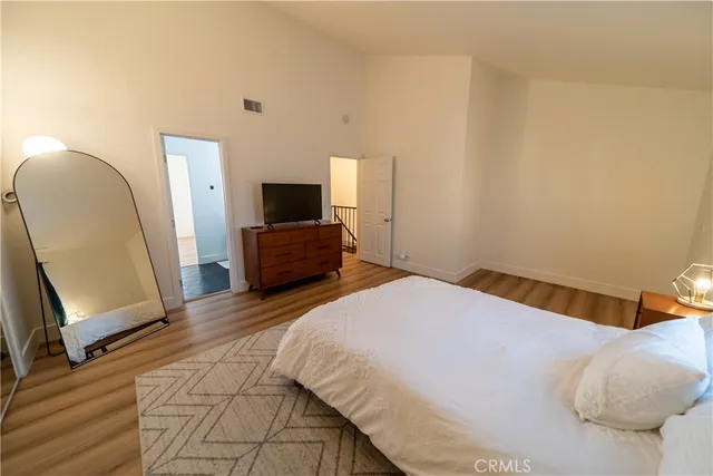 a bedroom with a bed and a mirror on dresser