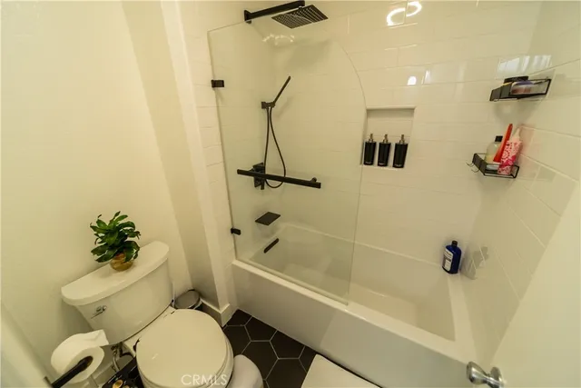 a white toilet sitting next to a bath tub