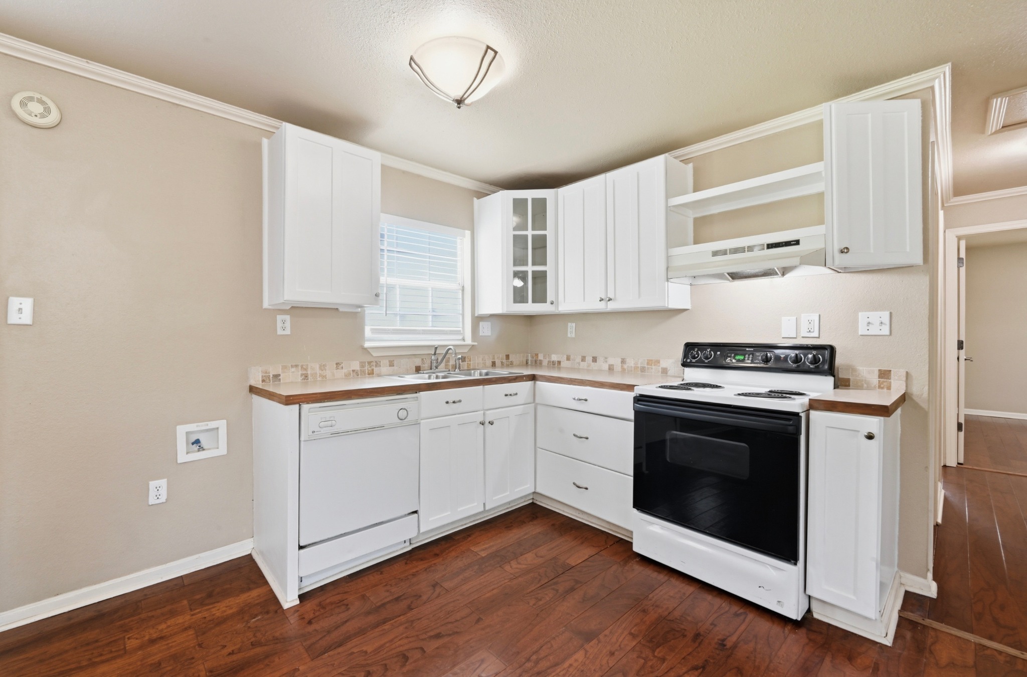1127 Parr Street Luling, TX 78648 - Photo 9 of 20 A well-equipped kitchen features white cabinetry, wood flooring, and modern appliances.