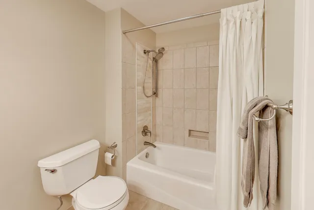a view of an empty room with closet and a window