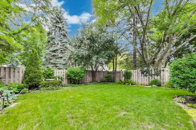 a view of a house with a yard and potted plants