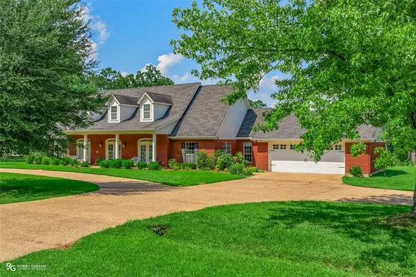 a front view of a house with a yard and trees