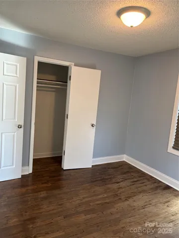an empty room with wooden floor and closet