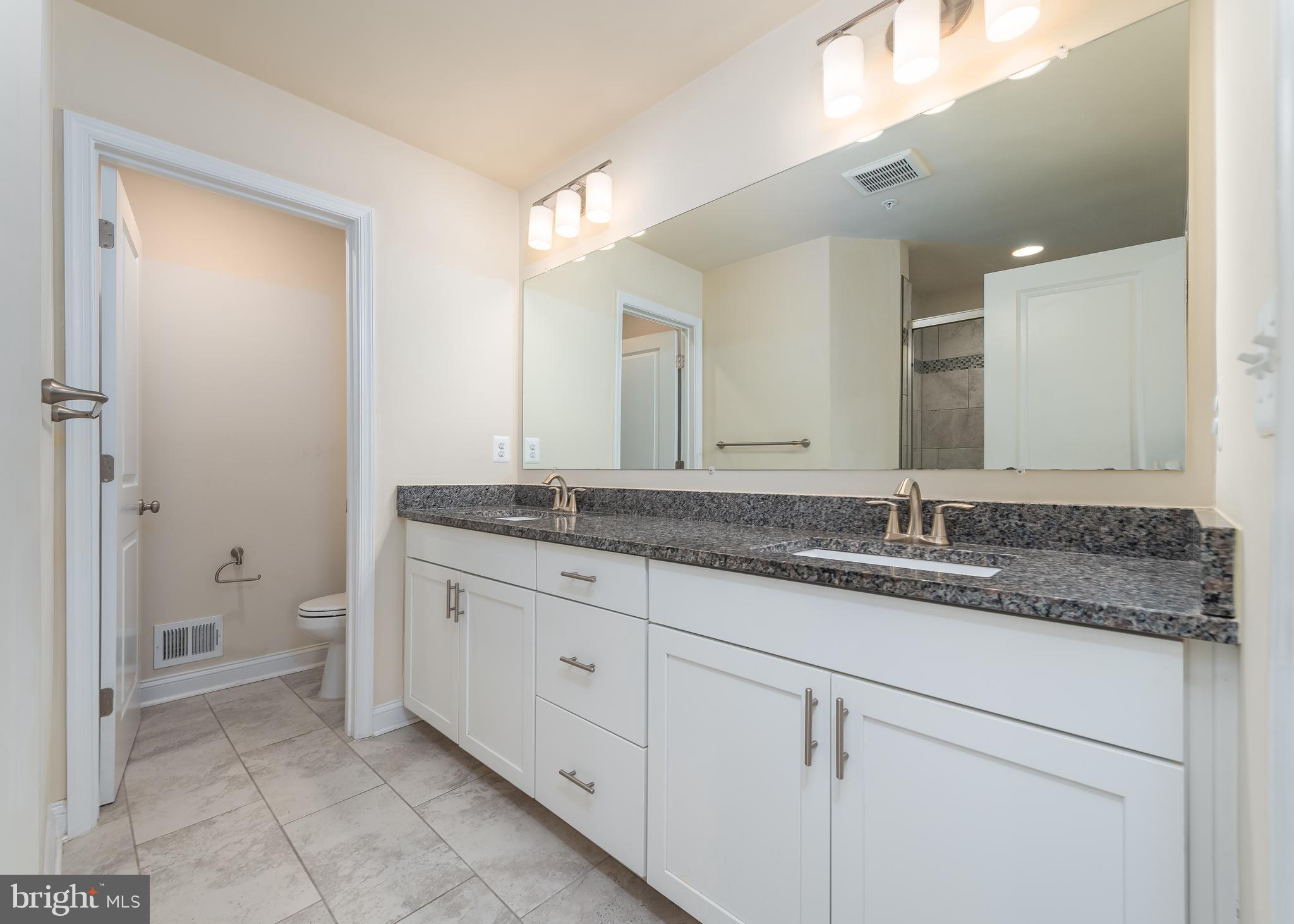 7038 Rackham Way Hanover, MD 21076 - Photo 14 of 30 a bathroom with a granite countertop sink mirror and toilet