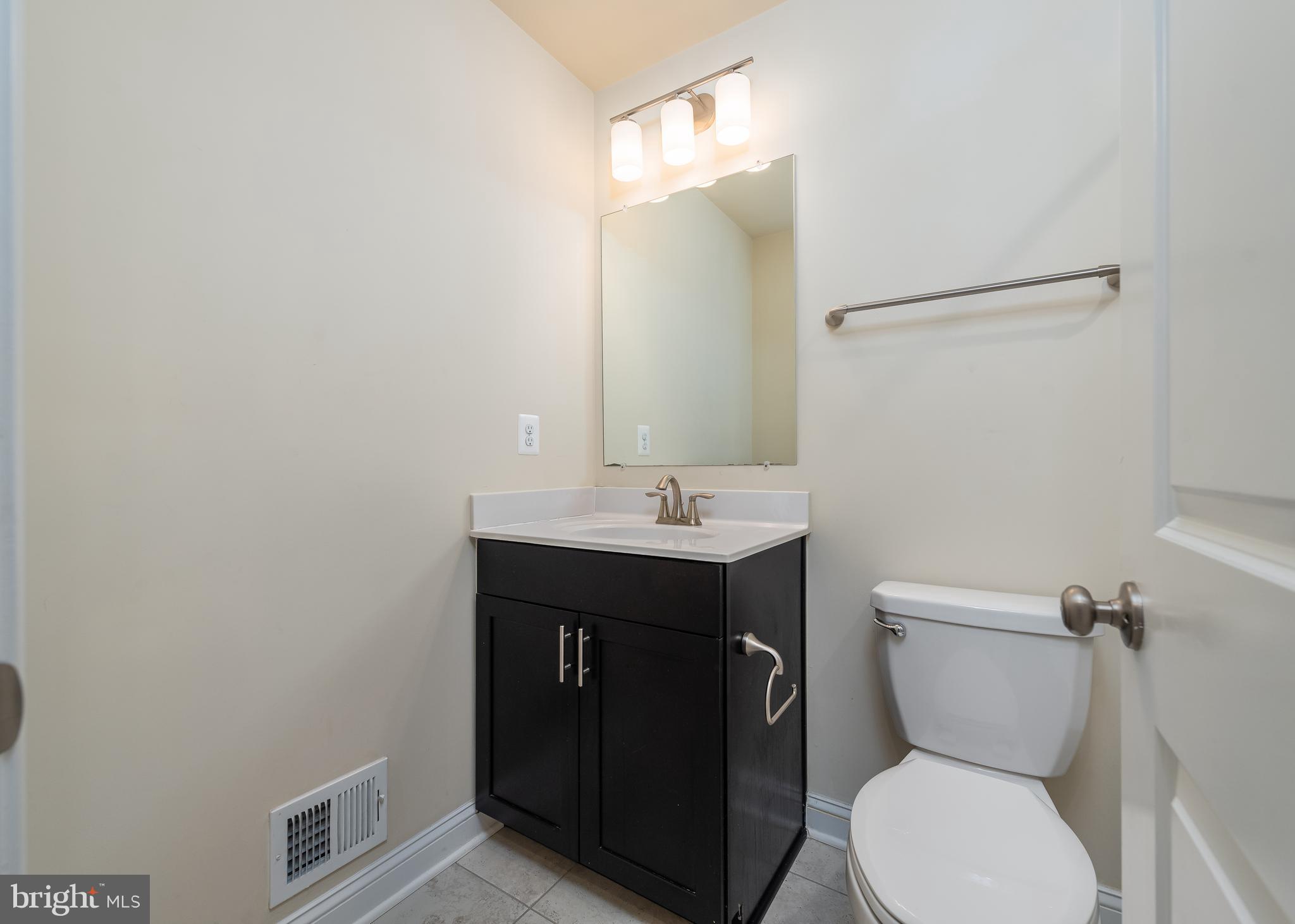 7038 Rackham Way Hanover, MD 21076 - Photo 18 of 30 a bathroom with a toilet sink and mirror