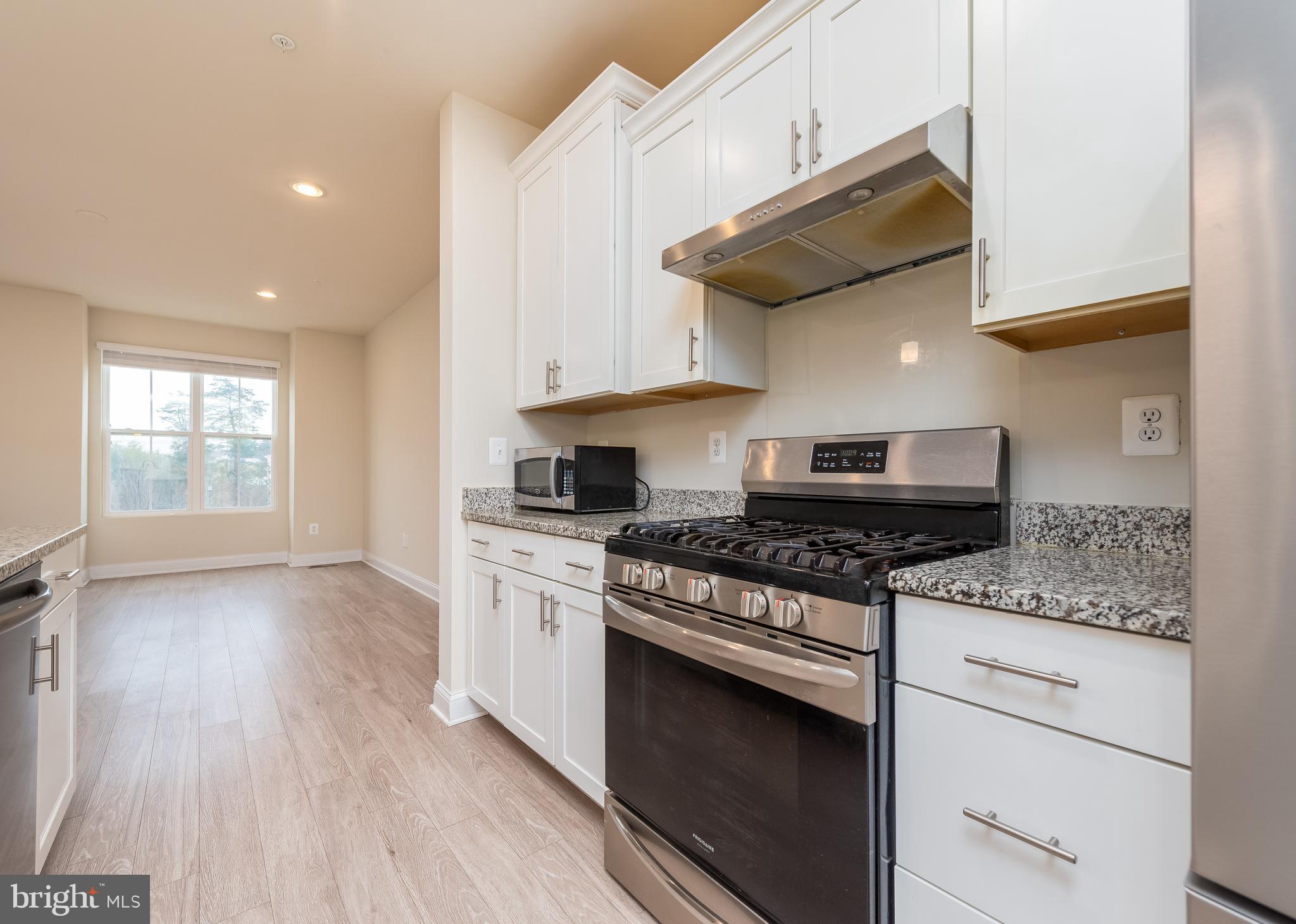 7038 Rackham Way Hanover, MD 21076 - Photo 5 of 30 a kitchen with stainless steel appliances granite countertop a stove and a wooden cabinets
