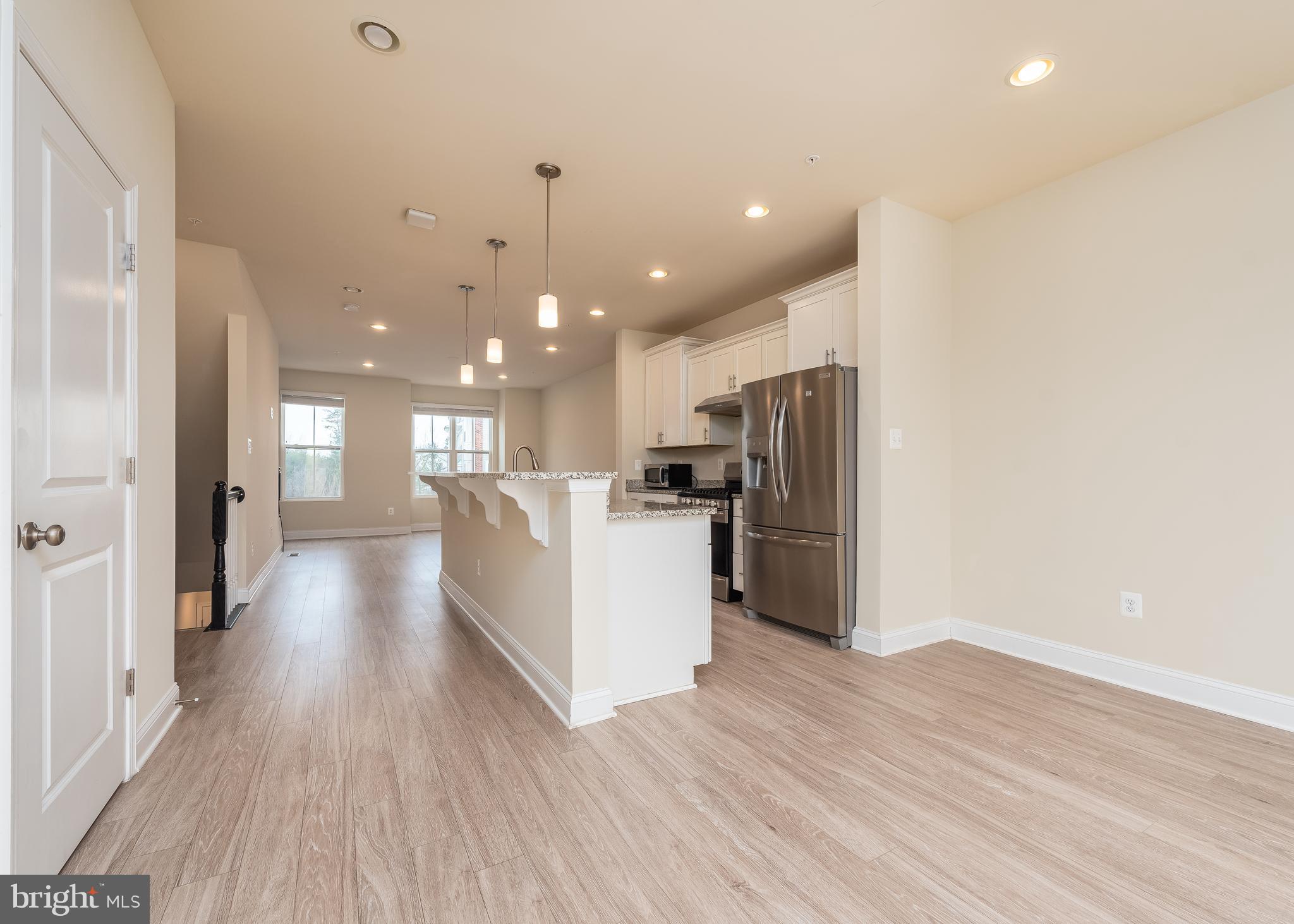 7038 Rackham Way Hanover, MD 21076 - Photo 6 of 30 a view of kitchen with refrigerator microwave and wooden floor