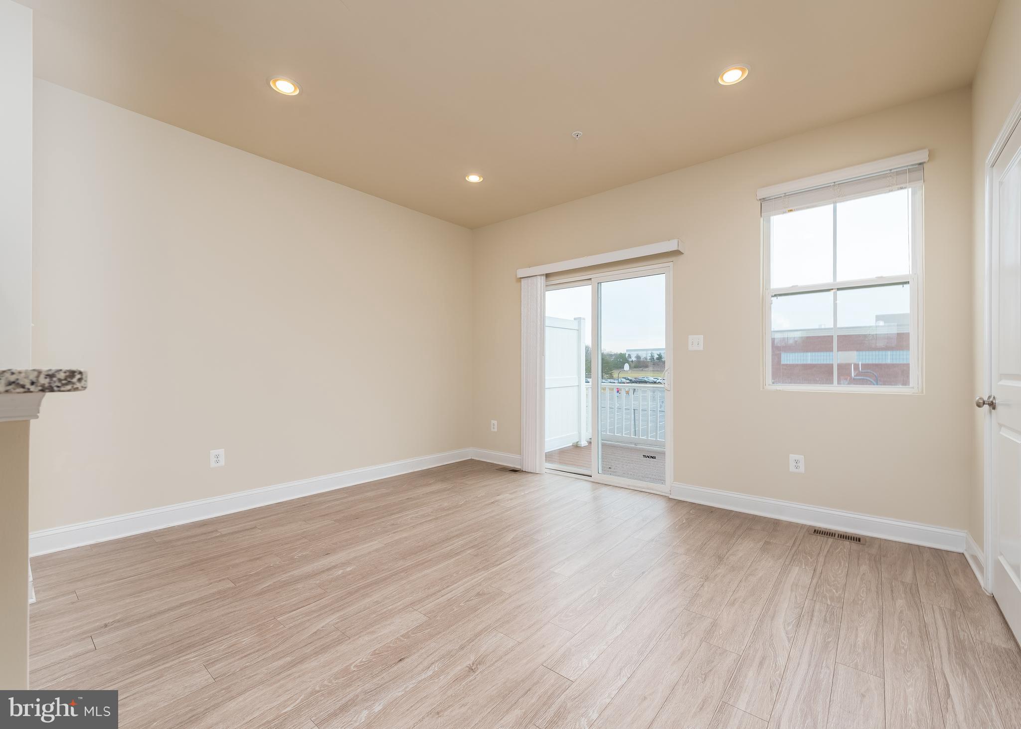 7038 Rackham Way Hanover, MD 21076 - Photo 9 of 30 an empty room with wooden floor and windows