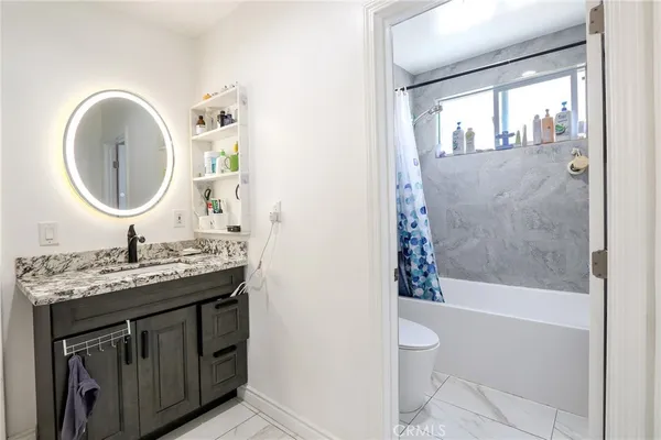a bathroom with a granite countertop sink toilet and shower