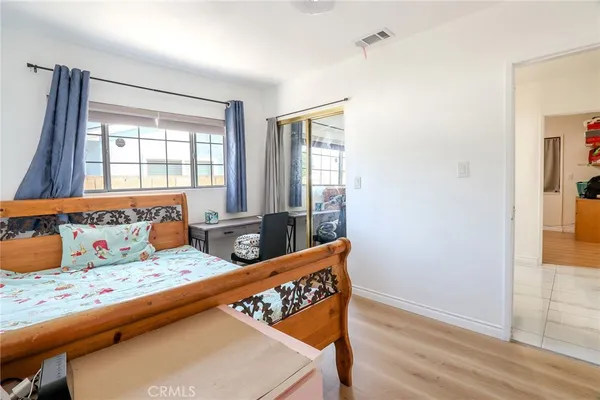 a bedroom with bed and wooden floor