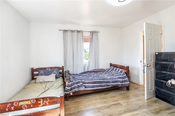 a walk in closet with wooden floor