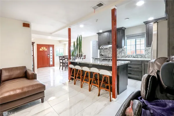 a living room with furniture kitchen view and a large window