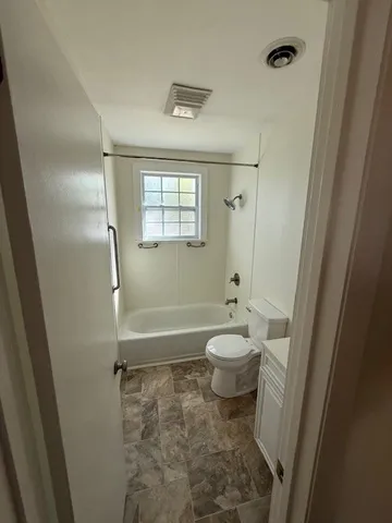 a bathroom with a toilet and a shower