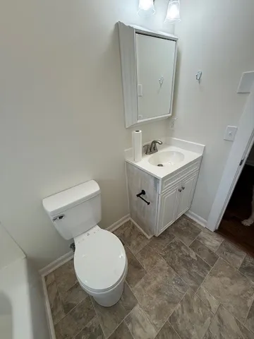 a bathroom with a sink vanity and toilet