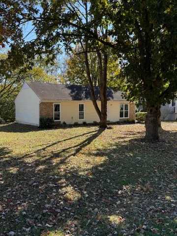 a view of a house with backyard and tree