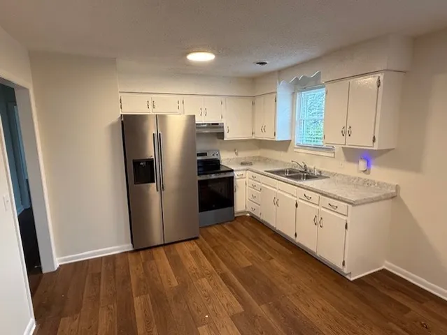 a kitchen with white cabinets and stainless steel appliances