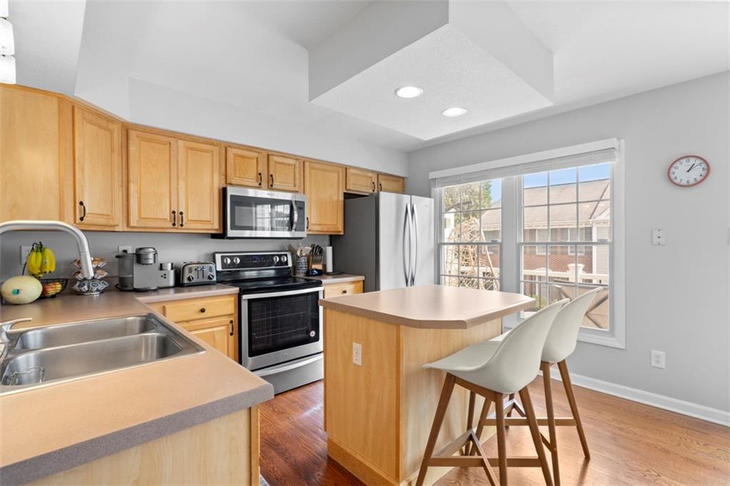 23 Castle View Drive McKees Rocks, PA 15136 - Photo 11 of 27 a kitchen with stainless steel appliances granite countertop a stove top oven a sink dishwasher a dining table and chairs with wooden floor