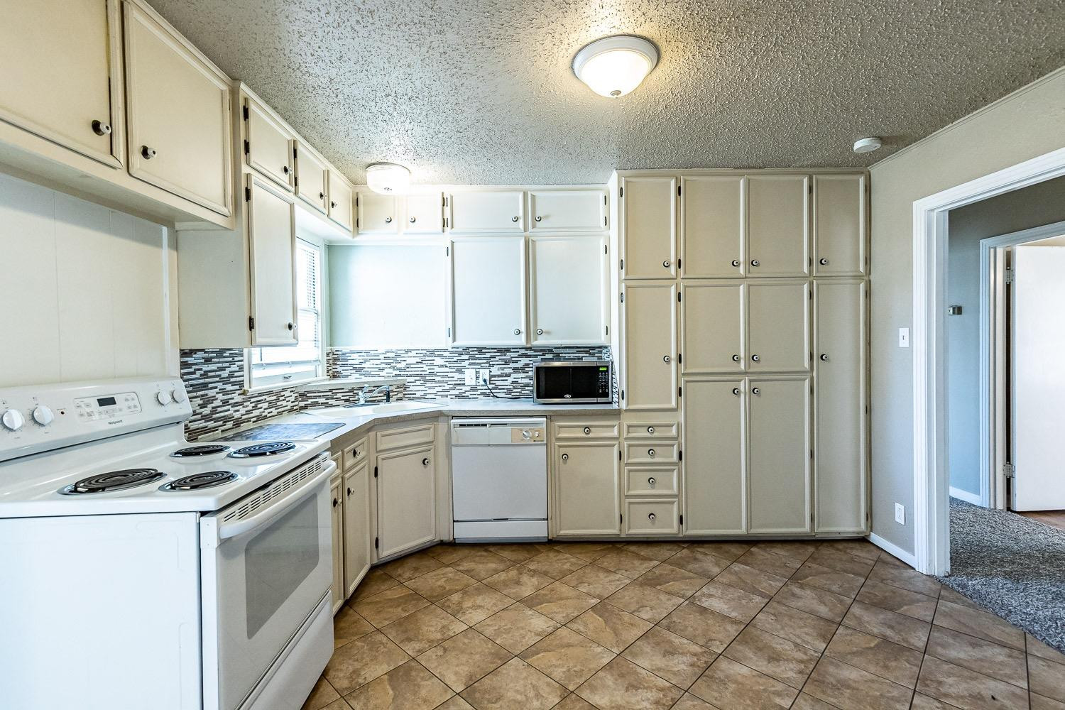 3708 27th Street Lubbock, TX 79410 - Photo 8 of 23 a kitchen with stainless steel appliances granite countertop a stove a sink and a refrigerator