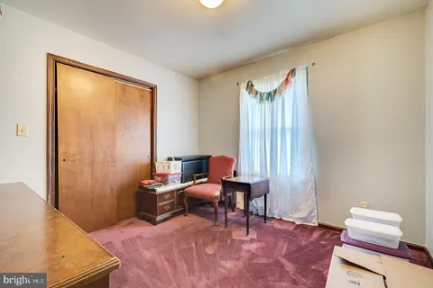 a view of a livingroom with workspace and a window