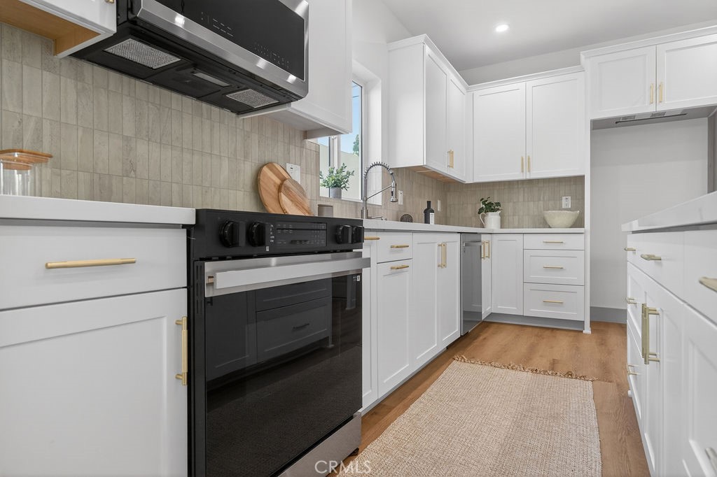 15540 Colorado Avenue Paramount, CA 90723 - Photo 13 of 63 a kitchen with white cabinets stainless steel appliances and sink