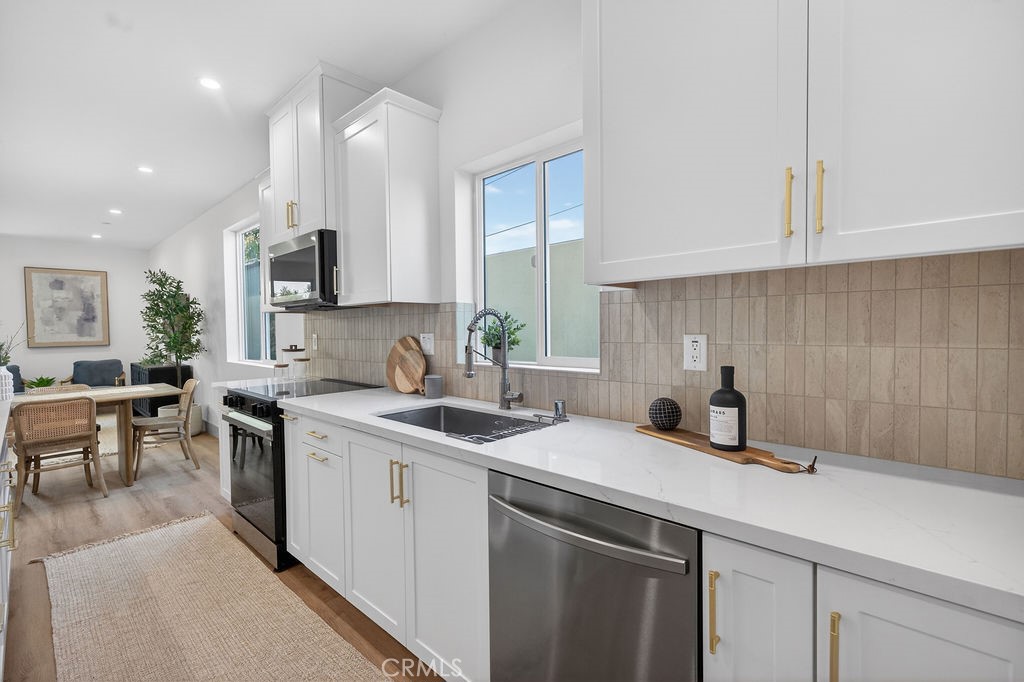 15540 Colorado Avenue Paramount, CA 90723 - Photo 15 of 63 a kitchen with a sink stove and cabinets