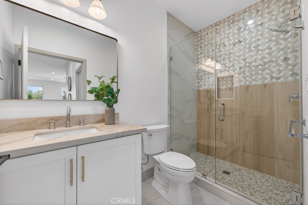 15540 Colorado Avenue Paramount, CA 90723 - Photo 25 of 63 a bathroom with a granite countertop sink a toilet and shower