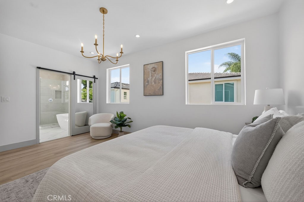 15540 Colorado Avenue Paramount, CA 90723 - Photo 31 of 63 a bedroom with a large bed and a chandelier