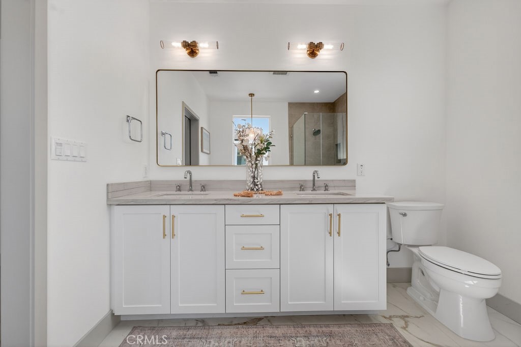 15540 Colorado Avenue Paramount, CA 90723 - Photo 38 of 63 a bathroom with a granite countertop sink a toilet and mirror