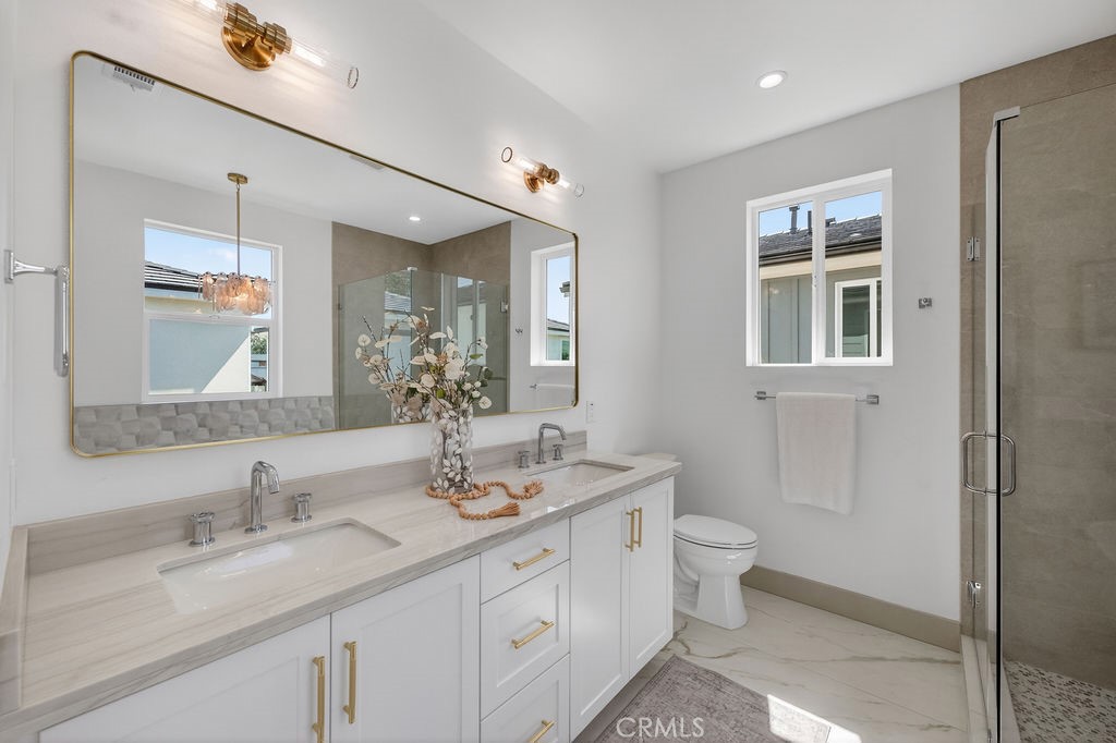 15540 Colorado Avenue Paramount, CA 90723 - Photo 40 of 63 a bathroom with a granite countertop double vanity sink a mirror and a toilet