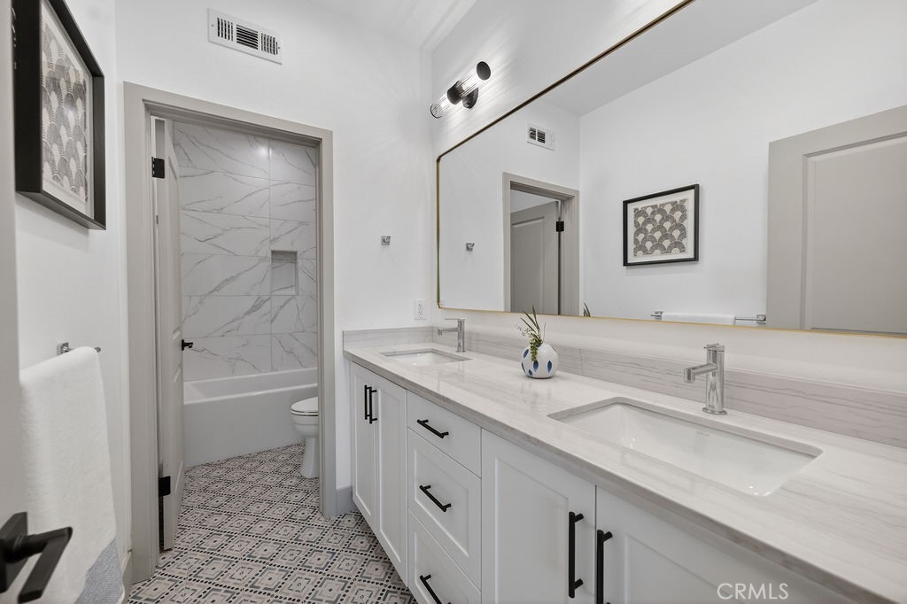 15540 Colorado Avenue Paramount, CA 90723 - Photo 47 of 63 a bathroom with a granite countertop sink mirror and a bath tub
