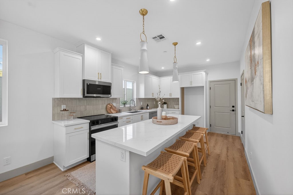 15540 Colorado Avenue Paramount, CA 90723 - Photo 9 of 63 a kitchen with a sink a counter top space stainless steel appliances and cabinets