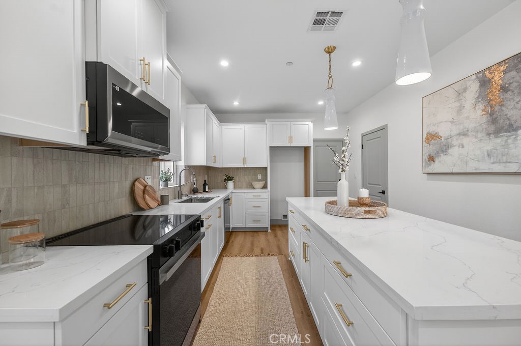 15540 Colorado Avenue Paramount, CA 90723 - Photo 10 of 63 a kitchen with a sink stove and microwave