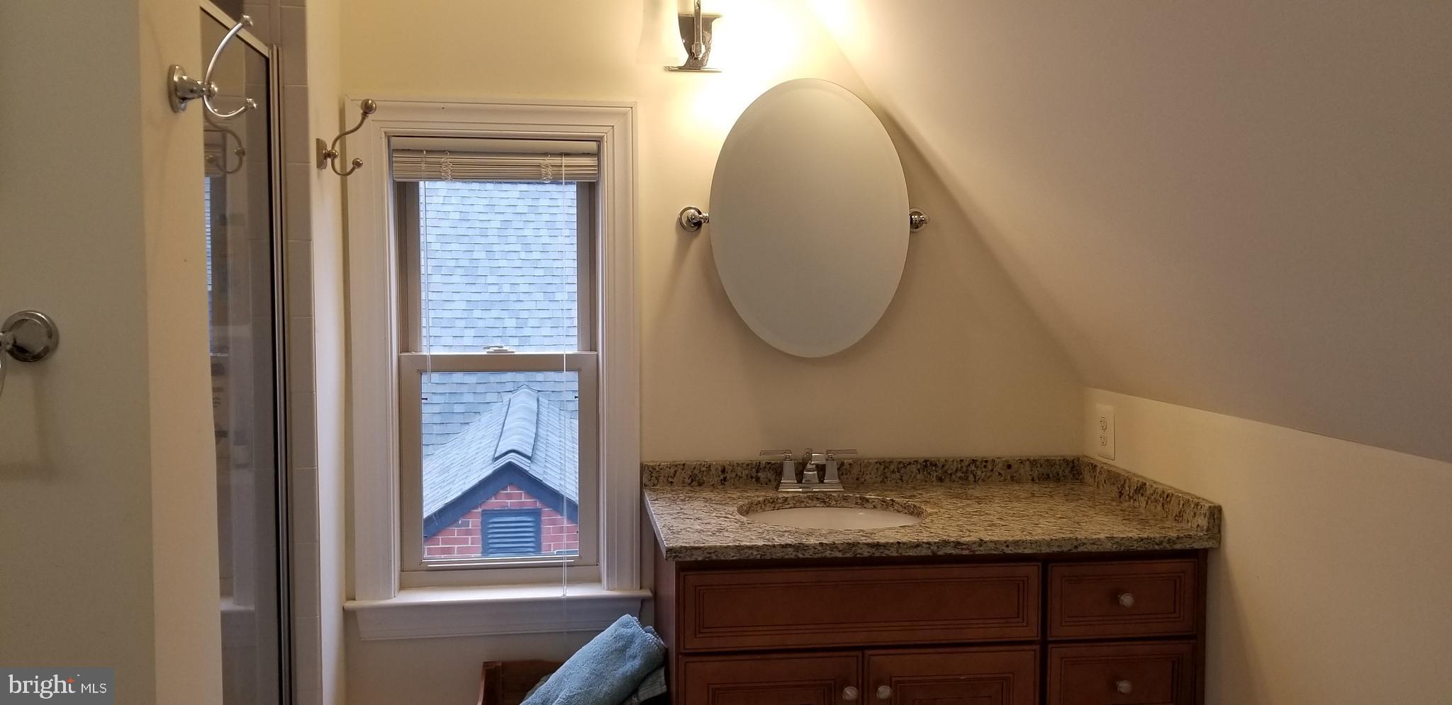 1709 Forest Glen Road Silver Spring, MD 20910 - Photo 34 of 61 a bathroom with a granite countertop sink a mirror and a wooden floor